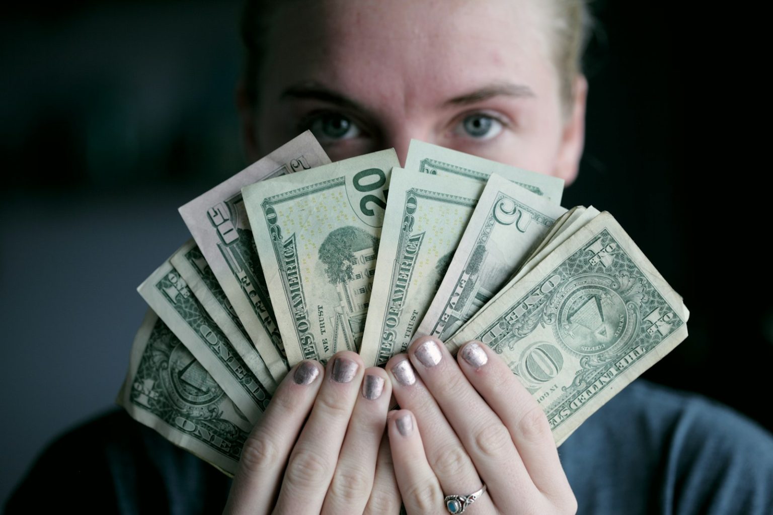 How Much AI Virtual Influencers Earn on Social Media person holding fan of U.S. dollars banknote