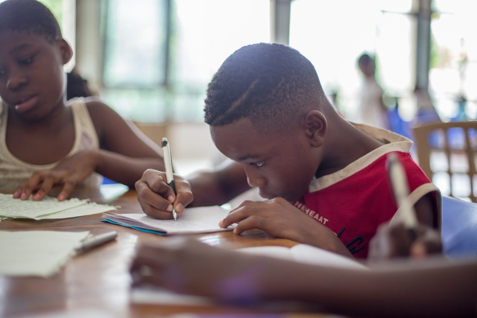 Black Academics Face Barriers in UK Universities boy writing on printer paper near girl